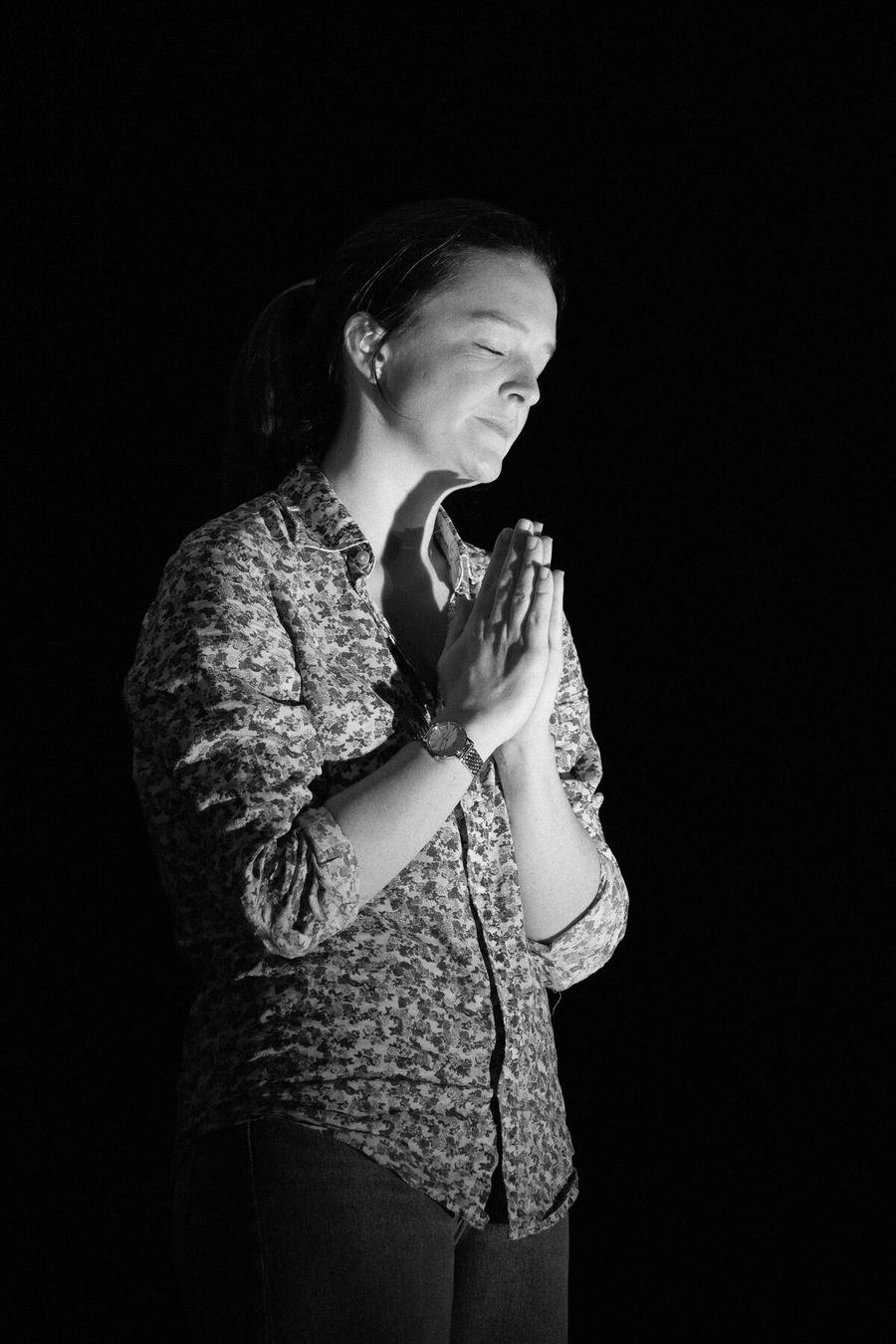Sybille Montagne, mains jointes, en prière dans un faisceau de lumière